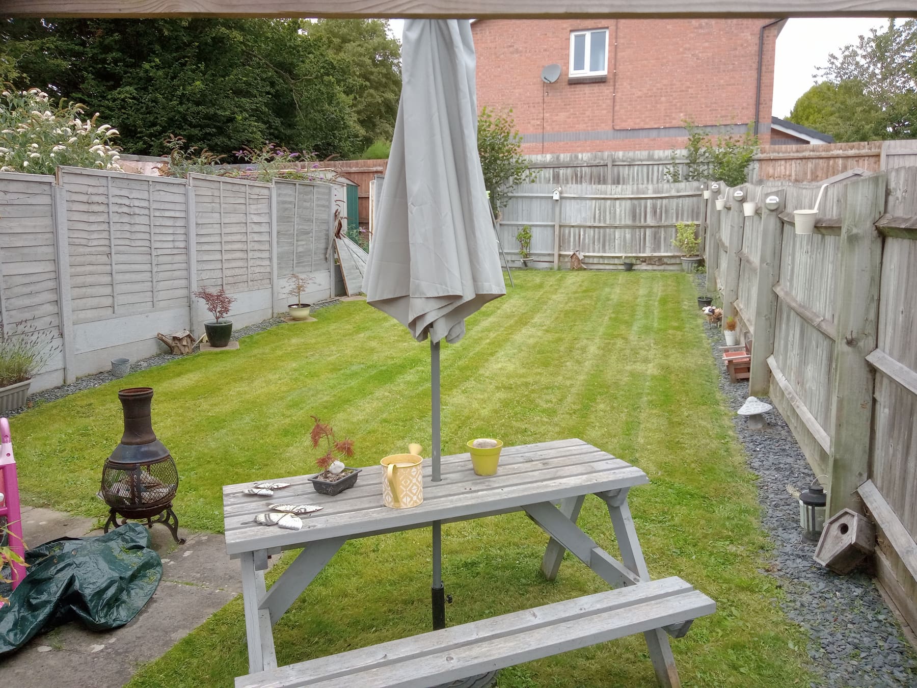 Neatly striped long rear garden lawn